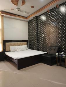 a bedroom with a large bed and a chair at Hotel Star View Bahawalpur in Bahawalpur
