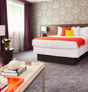 ヨンカーズにあるThe Royal Regency Hotelのベッドルーム1室(大型ベッド1台、赤と黄色の枕付)