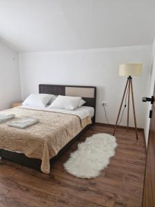 a bedroom with a bed and a white rug at Knežević apartman in Podgorica