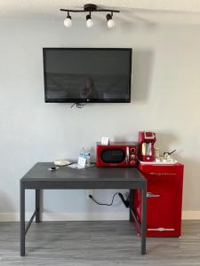 a table with a microwave and a tv on a wall at Motel Tipton in Tipton