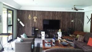 Una sala de estar con un sofá y un televisor de pantalla plana. en REB Casa Itanhangá, en Río de Janeiro