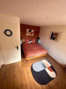 a bedroom with a bed and a rug on the floor at Petite maison de village 2 in Saint-Maurice-de-Rémens