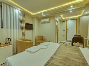 a room with a bed and chairs and a table at GALATAGREENAPPLEHOTEL in Istanbul