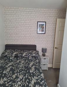 a bedroom with a bed and a brick wall at Hertfordshire in Letchworth