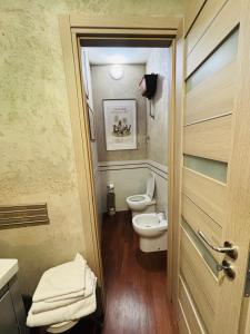 a bathroom with a toilet and a sink and a door at Cubiculla Monte Mario in Rome