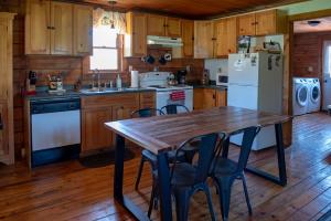 a kitchen with a wooden table and a refrigerator at Mill Creek Cabins in Lodi