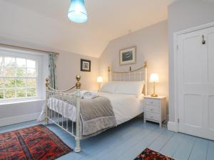 a bedroom with a white bed and a window at Trenouth Cottage in Padstow