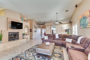 a living room with brown leather furniture and a tv at Heated Pool at 3 BR Home 5 Mi to Coachella! in La Quinta