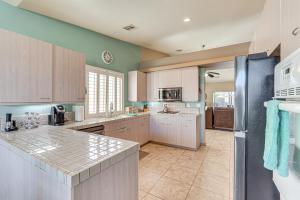 a large kitchen with white cabinets and a refrigerator at Heated Pool at 3 BR Home 5 Mi to Coachella! in La Quinta