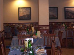 uma sala de jantar com mesas e cadeiras com garrafas em Albergo La Rocca em Assis