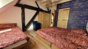 a bedroom with two beds and a wooden wall at Sfeervolle groepsaccommodatie met hottub in natuurgebied in Wateren