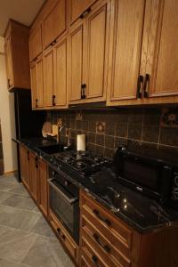 una cucina con mobili in legno e un forno a piano cottura di Old Gyumri in a new style Հին Գյումրին նոր ոճով Старый Гюмри в новом стиле a Gyumri