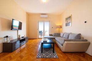 a living room with a couch and a flat screen tv at MY DALMATIA - Sea view apartment Nika with private parking in Posedarje
