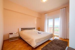 a bedroom with a bed and a large window at MY DALMATIA - Sea view apartment Nika with private parking in Posedarje