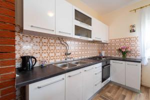 a kitchen with white cabinets and a sink at MY DALMATIA - Sea view apartment Nika with private parking in Posedarje +36 photos