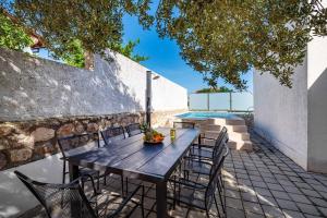 a wooden table and chairs on a patio at MY DALMATIA - Sea view apartment Dajana with private pool in Maslenica