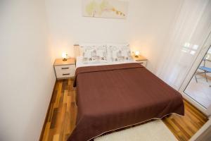 een bed in een kleine kamer met twee lampen op een tafel bij MY DALMATIA - Apartment ViGo with private pool in Bokanjac +27 foto's