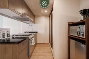 a kitchen with a sink and a microwave at Brand New 2 BR Condo in Reforma - King Beds in Mexico City +26 photos