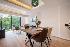 a dining room and living room with a table and chairs at Brand New 2 BR Condo in Reforma - King Beds in Mexico City