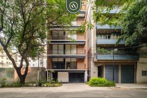 an apartment building with a parking lot in front of it at Brand New 2 BR Condo in Reforma - King Beds in Mexico City