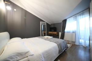 a bedroom with a large bed and a large window at Pensiunea La Ancuța-n Bucovina in Voronet +27 photos