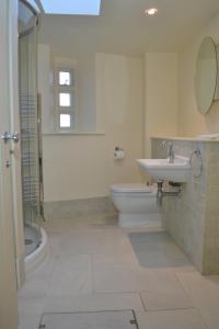 a bathroom with a sink and a toilet and a shower at Pear Tree Cottage in Shaldon +15 photos