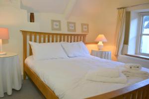 a bedroom with a bed with towels on it at Pear Tree Cottage in Shaldon