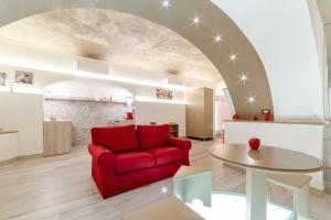 a living room with a red couch and a table at Open space letto Queensize con vista doccia in Cava deʼ Tirreni