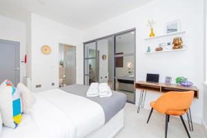 a bedroom with a bed and a desk and a chair at Elegant 2 Beds, 2 Baths Flat with Private Terrace, High-End Finishes and Chic Furnishings in London