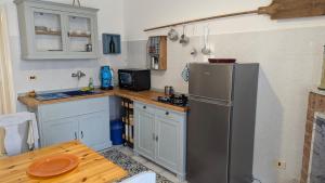 a kitchen with a stainless steel refrigerator and a table at Casa Emilia in Carovigno +20 photos