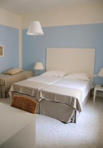 トラーパニにあるAlbaChiara Suite Rooms - City Centerのベッドルーム1室(ベッド2台、テーブル、ランプ付)