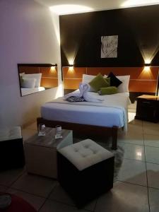 a bedroom with a large bed and a chair at Hotel Villa Capricce in Puente Piedra