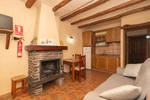 a living room with a fireplace and a kitchen at Muley Hacén in Capileira