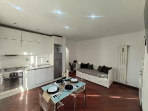 a kitchen and living room with a table and a couch at Mia Domus Guest Holiday in Ciampino