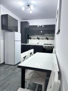 a kitchen with a table and a white refrigerator at Pensiunea Giulia in Afumaţi +18 photos