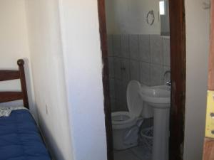 a small bathroom with a toilet and a sink at Pousada Chalés do Lago in Cavalcante