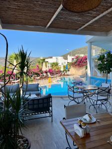 a patio with tables and chairs and a swimming pool at The Bay View Boutique Hotel Kalkan in Kas