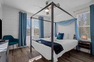 1 dormitorio con cama con dosel y cortinas azules en New Durham-10 min to Duke-1m Dtwn-FencedYard, en Durham