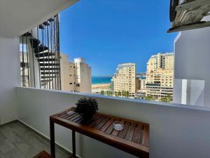 a balcony with a bench and a view of the city at Central Large Suite with Balcony & Beach view in Tangier