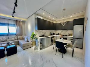 a kitchen and living room with a couch and a table at Central Large Suite with Balcony & Beach view in Tangier