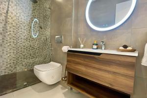 a bathroom with a toilet and a sink and a shower at Central Large Suite with Balcony & Beach view in Tangier +13 photos