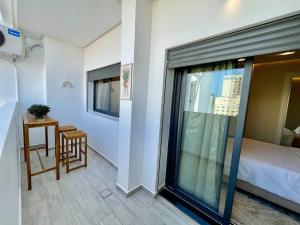 a room with a bed and a table and a window at Central Large Suite with Balcony & Beach view in Tangier