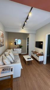 a living room with a large bed and a television at Apê Coloridinho - Centro in Serra Negra