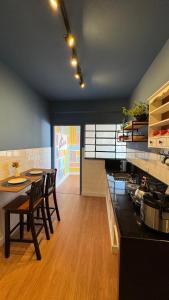 a kitchen with a table and chairs and a stove at Apê Coloridinho - Centro in Serra Negra