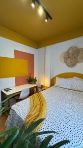 a bedroom with a bed and a desk with a desk at Apê Coloridinho - Centro in Serra Negra