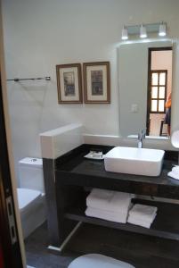 uma casa de banho com um lavatório, um WC e um espelho. em Ochenta Y Dos Bed & Breakfast & Spa em Mérida