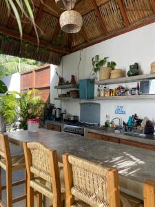 a kitchen with a counter and a table and chairs at Casa De La Palmera in Brisas de Zicatela