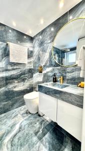 ein Badezimmer mit Waschbecken und Spiegel in der Unterkunft THE OCEAN - Luxury Apartment at the Harbor in Paphos + 25 Fotos