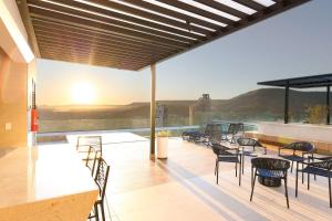 a balcony with chairs and tables and a view of the mountains at Estúdios modernos no City House by WeHousy in Barreiras