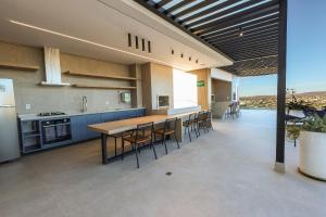 a large kitchen with a table and chairs in it at Estúdios modernos no City House by WeHousy in Barreiras
